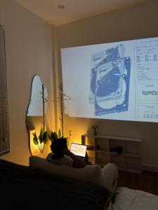 una persona seduta su un divano davanti a una presentazione di June Homestay a Hue