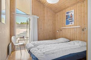 a bedroom with a bed in a wooden wall at 1563-Aakirkeby-Strandparken-8 in Vester Sømarken