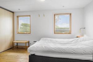 a bedroom with a white bed and two windows at OH506-Hadsund-Gl-Hedegaardsvej-4 in Hadsund