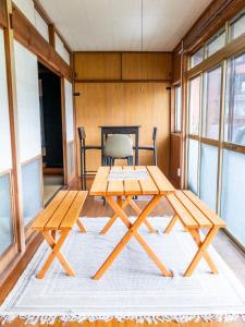 a table and benches in a room with windows at Gracciaso in Aso