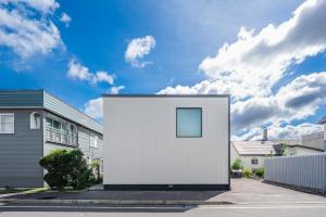 a white building on the side of a street at S suzukou in Asahikawa
