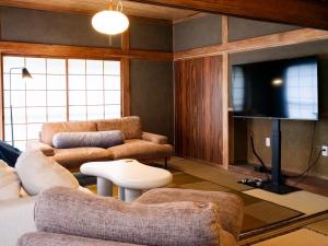 a living room with two couches and a flat screen tv at Gracciaso in Aso