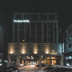 a building with a sign on top of it at night at The Classic by Hotelone in Jeonju