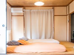 a bed in a room with a window at Gracciaso in Aso