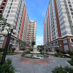 a fountain in a courtyard with tall buildings at Homestay Ngôi Nhà Nhỏ in Kinh Dinh
