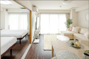 札幌市にあるSapporo Residence 14のベッド2台とソファのあるリビングルーム