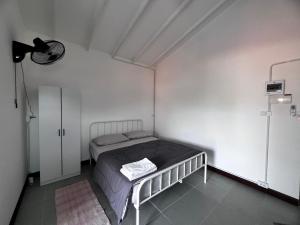een slaapkamer met een bed in een witte kamer bij Koh Lipe Apartment in Satun
