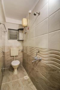 a bathroom with a toilet and a shower at Hotel Aadya Executive in Pune