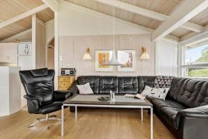 a living room with a black leather couch and a table at OH204-Hadsund-Bondes-Bakke-26 in Hadsund