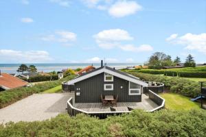 a black house with a deck and the ocean at OH204-Hadsund-Bondes-Bakke-26 in Hadsund