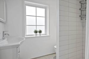 ein weißes Badezimmer mit Fenster und zwei Topfpflanzen in der Unterkunft OH362 Storvorde - Kongeørnen 74 in Storvorde + 20 Fotos