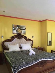 a bedroom with a large bed with yellow walls at Terrasse Beach Resort in Mambajao
