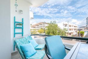 Un balcón con sillas azules y una mesa y una vista. en Cuentame, en Alcudia