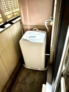 baño pequeño con lavadora y secadora en shibuya Honmachi Studio, en Tokio