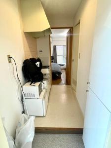Un pasillo con una habitación con cajas y una mochila. en shibuya Honmachi Studio, en Tokio