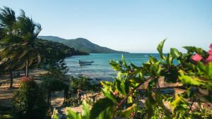 a view of a beach with a boat in the water at Legon Waru Cottage in Karimunjawa