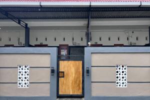 a couple of garage doors with a wooden door at TwoSpaces Living at Bunda Nana Residence, Gianyar in Gianyar
