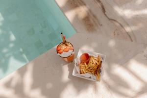 a cup of french fries and an apple on a table at El Campo Mushroom in Nusa Lembongan