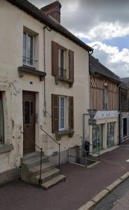 a building with stairs and windows on a street at Le cocon melois in Le Mêle-sur-Sarthe