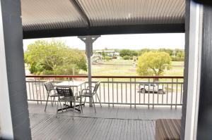a patio area with chairs, a table and a balcony at Royal Gatton Hotel in Gatton