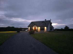 ein Haus mit nachts eingeschaltetem Licht in der Unterkunft The Single Room in Killinick