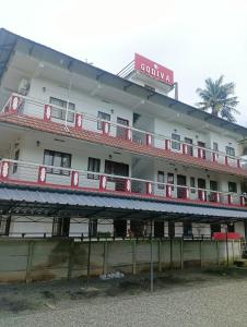 a large white building with red balconies at Godiva apartment in Cochin