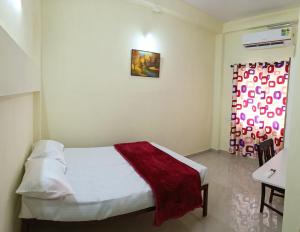 a bedroom with a white bed with a red blanket at Godiva apartment in Cochin +1 photo