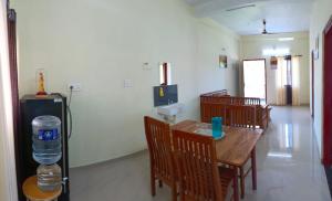 a dining room with a table and chairs and a water bottle at Godiva apartment in Cochin