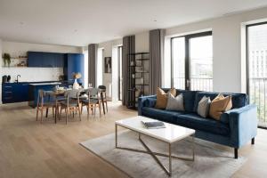 a living room with a blue couch and a table at Urban Rest Dublin Docklands in Dublin