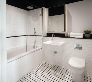 a bathroom with a toilet and a tub and a sink at Urban Rest Dublin Docklands in Dublin +12 photos