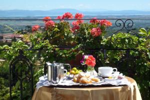 una mesa con un plato de comida y flores en ella en Albergo Il Marzocco dal 1860, en Montepulciano