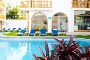 une piscine dans un hôtel avec des chaises longues bleues dans l'établissement Hotel Boutique La Angostura, à Ica