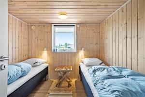 two beds in a room with wooden walls at OH287-Hadsund-Haslevgarde-Eng-1 in Hadsund