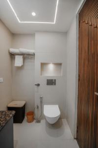 a white bathroom with a toilet and a sink at SaffronStays Library Enclave Maharajah Suite - 1-BHK Luxury Apt with Valley View, Mall Road Mussoorie in Mussoorie