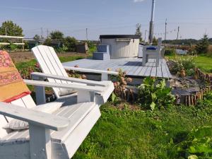 a white bench sitting on top of a wooden deck at Folwark i apartameny Malinowy Chruśniak in Bisztynek