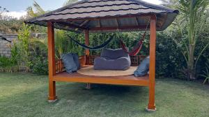 a gazebo with a hammock in a yard at Wind and Sea at Arista Lakey Peak House in Huu