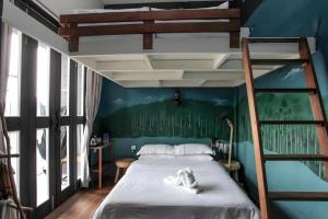 a bedroom with a bunk bed and a ladder at The Happy 8 Retreat @ Kuala Sepetang in Kampung Sepetang