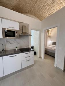 a kitchen with white cabinets and a room with a bed at Cuore di casa in Manfredonia
