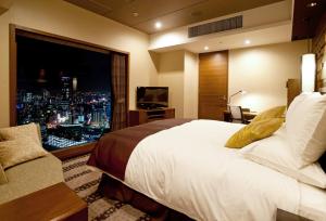 a hotel room with a large bed and a large window at Hotel Granvia Osaka-JR Hotel Group in Osaka