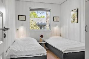 zwei Betten in einem weißen Zimmer mit Fenster in der Unterkunft OH507 Hadsund - Ved Fruerlund 1 in Hadsund