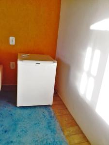 a small refrigerator in a corner of a room at Pousada do Caboclo in Ilhabela