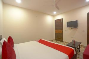 une chambre avec un lit et une télévision au mur dans l'établissement Hotel O Three Kings, à New Delhi