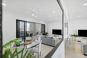 凯恩斯Mountain Air and Modern Flair 'Your Cairns Getaway'的客厅里有一张沙发和一张桌子。