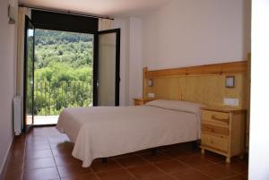 a bedroom with a bed and a large window at Apartamentos Casa Masover in Buira