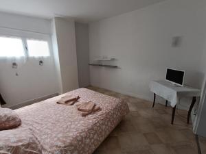 a bedroom with a bed and a desk with a laptop at Le relais de cap de pin in Solférino +1 photo