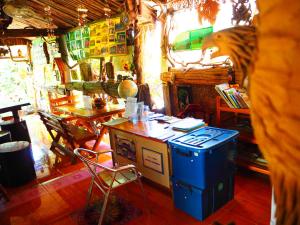 Habitación con fogones, mesa y sillas. en Three J Guesthouse en Kamphaeng Phet