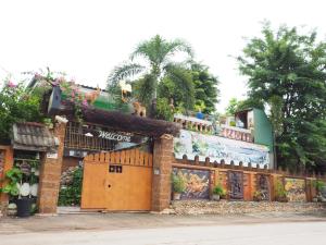 un bâtiment doté d'une clôture avec des animaux au-dessus dans l'établissement Three J Guesthouse, à Kamphaeng Phet