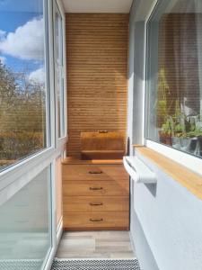 a balcony with a wooden drawer and a window at Blue apartment in Šiauliai +4 photos