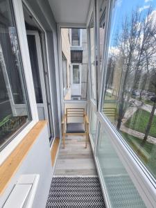 a room with windows and a chair on a porch at Blue apartment in Šiauliai