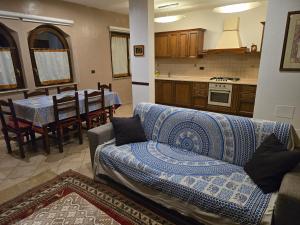 Una sala de estar con un sofá y una cocina. en Appartamento Rosa, en Aosta
